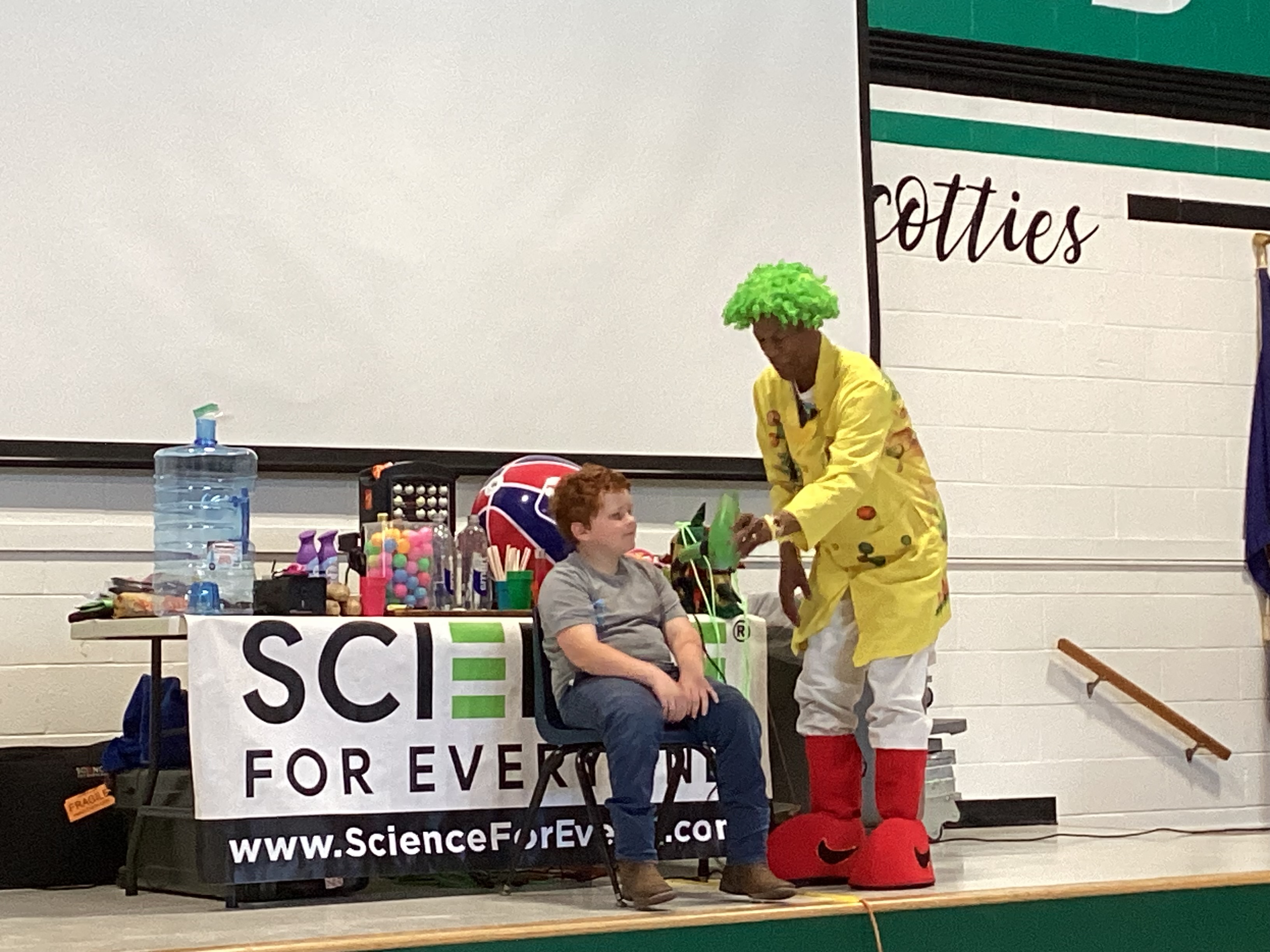 Science man doing experiment with boy in chair