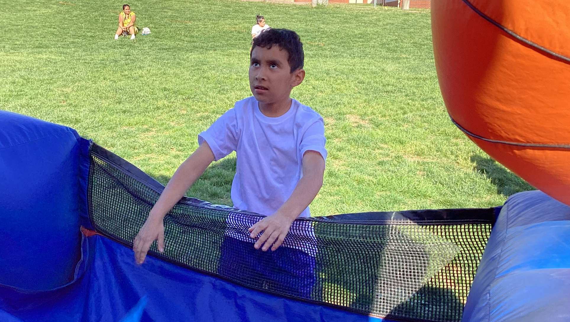 Student shooting ball at inflatable hoop