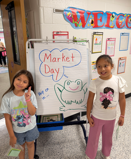 two girls with poster of frog